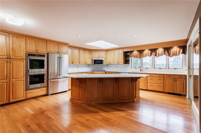7175 Gale Rd, Lima, NY 14485 - kitchen featuring appliances with stainless steel finishes, a skylight, a kitchen island, light countertops, and light wood-style floors