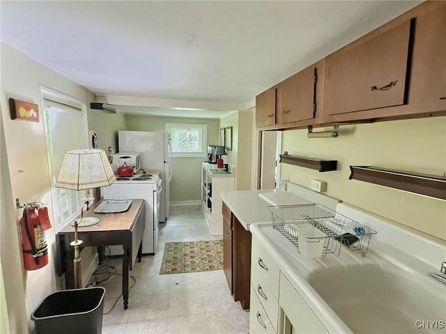 326 Main St, Ledyard, NY 13026 - kitchen with white range, light countertops, an office area, brown cabinetry, and light tile patterned floors
