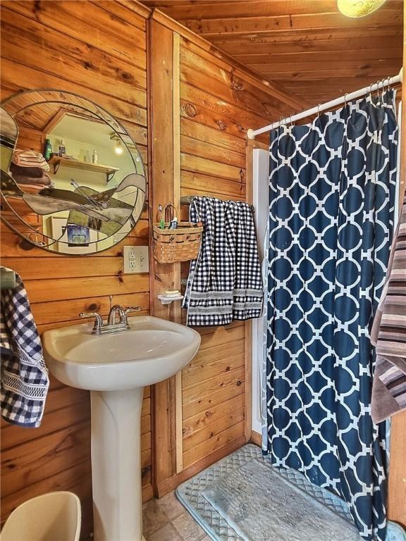 1995 Lake Rd, Ledyard, NY 13026 - bathroom featuring wood walls, wood ceiling, and a shower with shower curtain