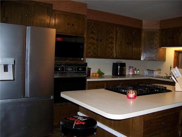 236 Covered Bridge Rd, Davenport, NY 13820 - kitchen featuring black appliances, light countertops, and a kitchen bar