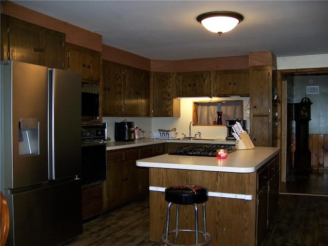 236 Covered Bridge Rd, Davenport, NY 13820 - kitchen featuring black appliances, dark wood-style flooring, light countertops, and a breakfast bar