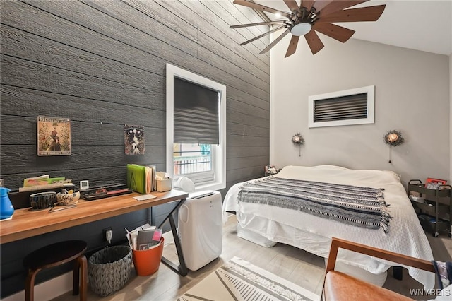 228 Potomac Ave, Buffalo, NY 14213 - bedroom featuring wood walls, vaulted ceiling, wood finished floors, and a ceiling fan