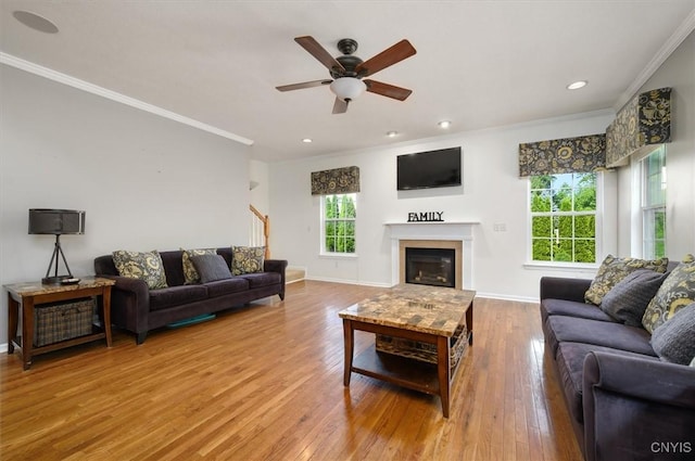 8278 Luchsinger Ln, Lysander, NY 13027 - living area with crown molding, ceiling fan, wood finished floors, a glass covered fireplace, and stairway