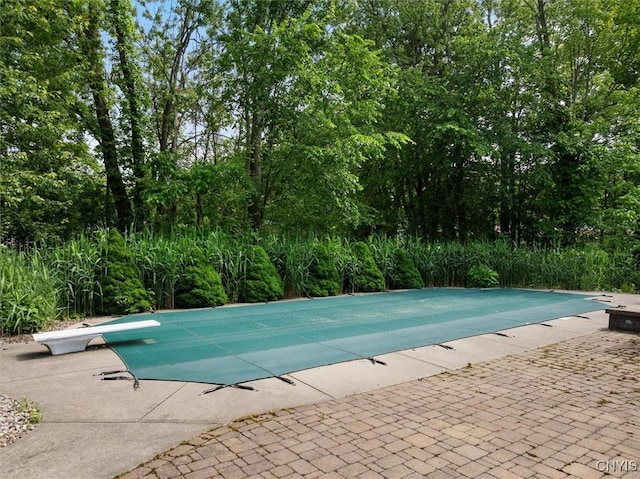8278 Luchsinger Ln, Lysander, NY 13027 - view of swimming pool featuring a diving board, a patio, and a covered pool