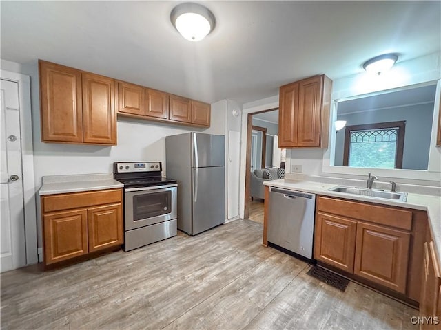22 Frank St, Cortland, NY 13045 - kitchen featuring appliances with stainless steel finishes, brown cabinetry, light countertops, and light wood-type flooring