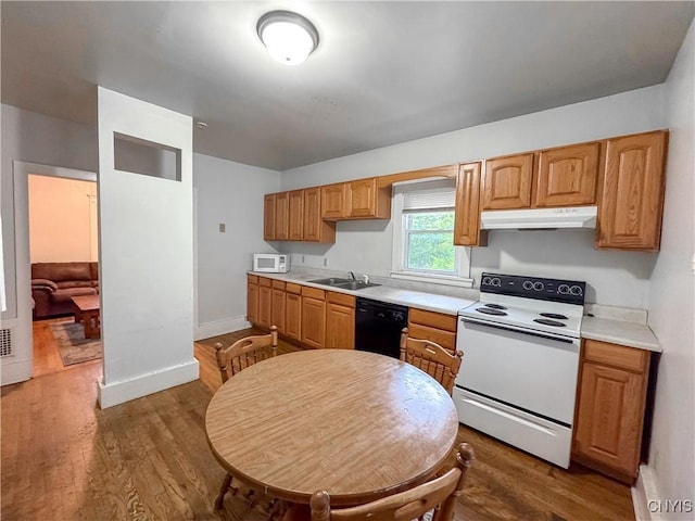22 Frank St, Cortland, NY 13045 - kitchen featuring white appliances, under cabinet range hood, light countertops, and dark wood-style flooring