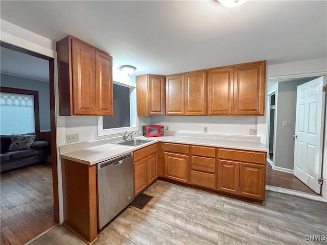 22 Frank St, Cortland, NY 13045 - kitchen with stainless steel dishwasher, light wood-style flooring, light countertops, and brown cabinetry