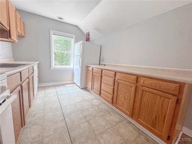19 Water St, Cortland, NY 13045 - kitchen with freestanding refrigerator, vaulted ceiling, light countertops, and range