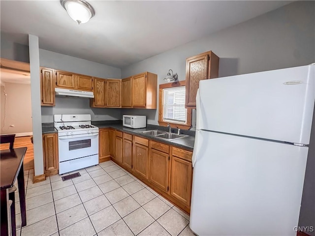 72 Groton Ave, Cortland, NY 13045 - kitchen featuring white appliances, dark countertops, light tile patterned floors, under cabinet range hood, and brown cabinets