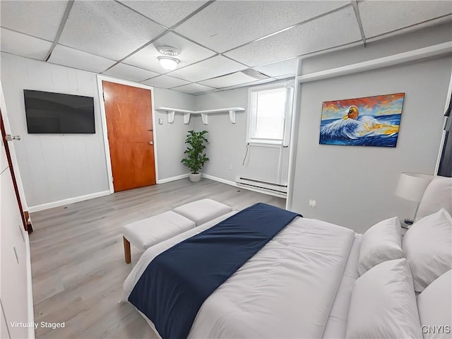 72 Groton Ave, Cortland, NY 13045 - bedroom with a baseboard radiator, a paneled ceiling, and wood finished floors