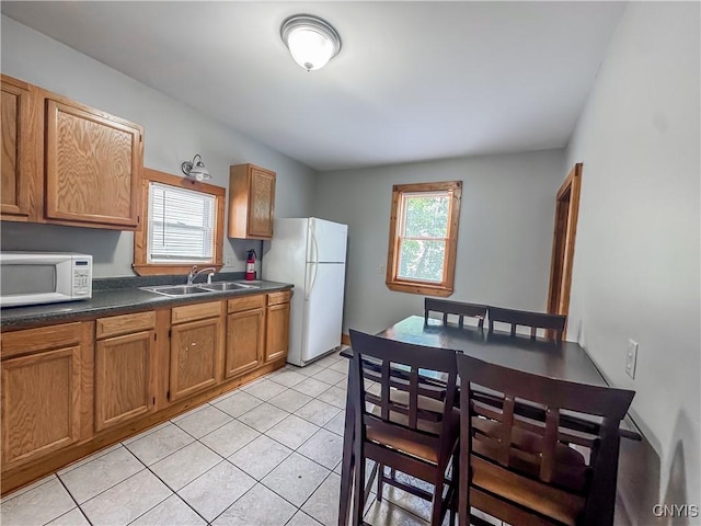 72 Groton Ave, Cortland, NY 13045 - kitchen featuring white appliances, healthy amount of natural light, dark countertops, and brown cabinetry