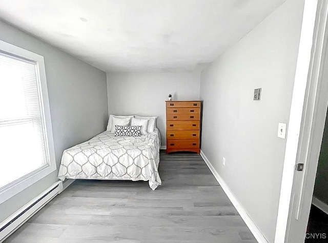 73 Groton Ave Unit 69-71, Cortland, NY 13045 - bedroom with a baseboard heating unit and wood finished floors