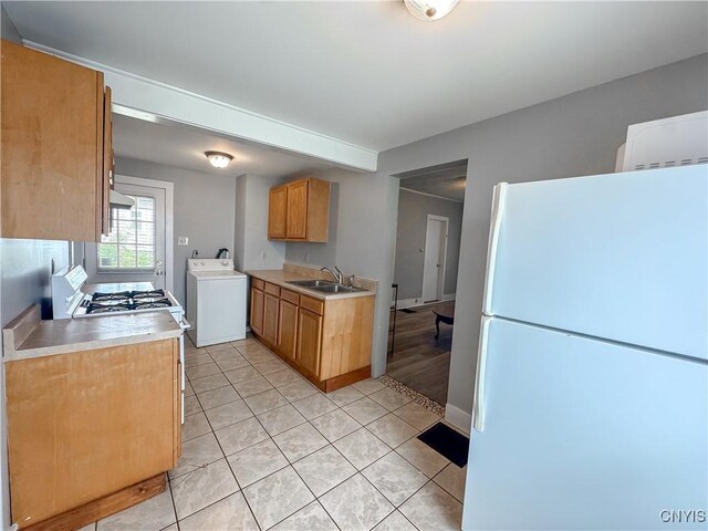 73 Groton Ave Unit 69-71, Cortland, NY 13045 - kitchen with freestanding refrigerator, washer / dryer, gas range oven, light tile patterned floors, and light countertops