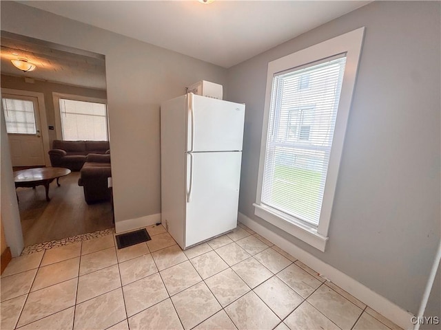 73 Groton Ave Unit 69-71, Cortland, NY 13045 - kitchen with freestanding refrigerator, healthy amount of natural light, and light tile patterned floors