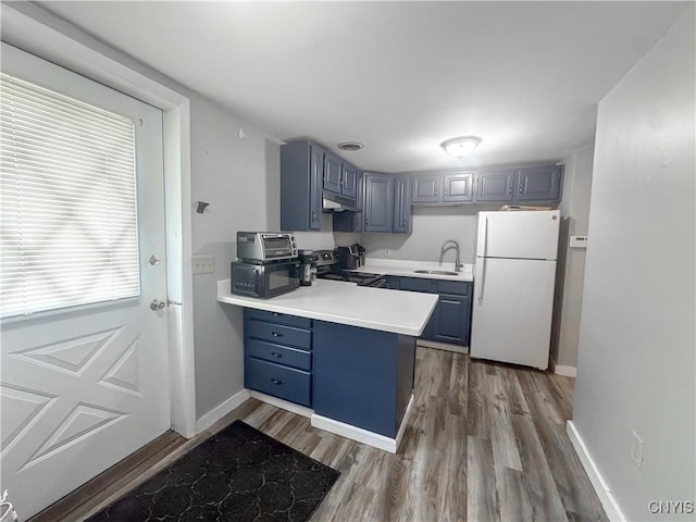 66 Groton Ave, Cortland, NY 13045 - kitchen with freestanding refrigerator, under cabinet range hood, electric range, a peninsula, and black microwave