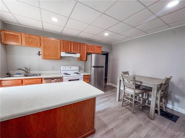 63 Groton Ave, Cortland, NY 13045 - kitchen with appliances with stainless steel finishes, under cabinet range hood, light wood-style floors, light countertops, and a paneled ceiling