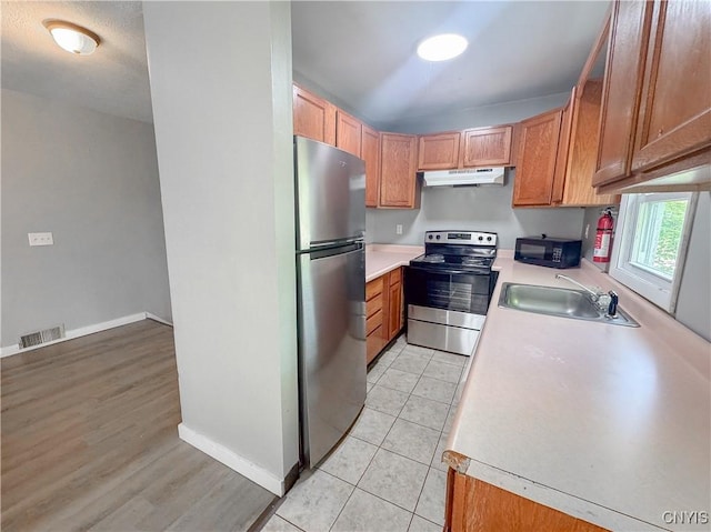 63 Groton Ave, Cortland, NY 13045 - kitchen with stainless steel appliances, under cabinet range hood, light countertops, and light tile patterned floors