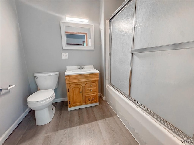 63 Groton Ave, Cortland, NY 13045 - bathroom featuring wood finished floors, vanity, and enclosed tub / shower combo
