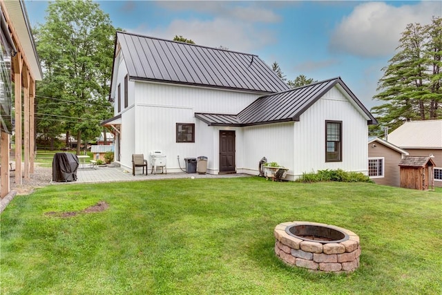 109 Unadilla Trail Rd, Pittsfield, NY 13411 - rear view of house featuring a standing seam roof, an outdoor fire pit, a metal roof, a patio, and a yard