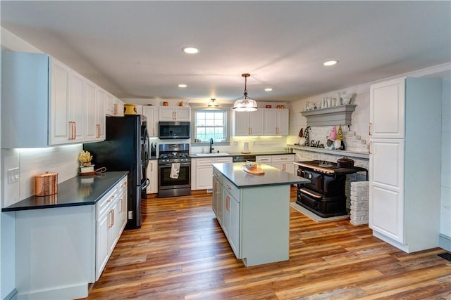 109 Unadilla Trail Rd, Pittsfield, NY 13411 - kitchen with appliances with stainless steel finishes, dark countertops, wood finished floors, white cabinets, and a center island