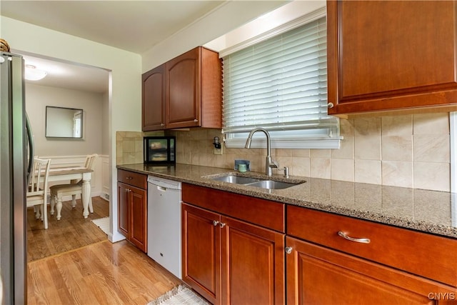 368 Northfield Way, Camillus, NY 13031 - kitchen featuring white dishwasher, freestanding refrigerator, dark stone countertops, light wood-style flooring, and tasteful backsplash