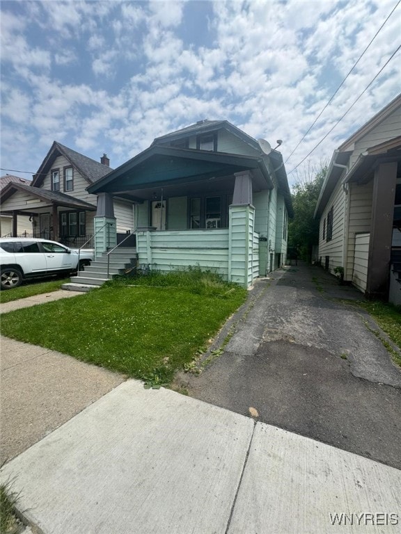 79 Freund St, Buffalo, NY 14215 - view of front of house featuring a porch, a front yard, and asphalt driveway