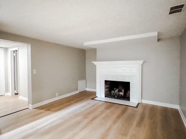 22 Yorkshire Rd, Irondequoit, NY 14609 - unfurnished living room featuring wood finished floors, a textured ceiling, and a fireplace
