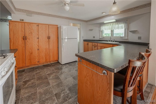 18 Eisenhower Dr, Lockport-City, NY 14094 - kitchen with white appliances, dark countertops, ceiling fan, a peninsula, and a kitchen bar