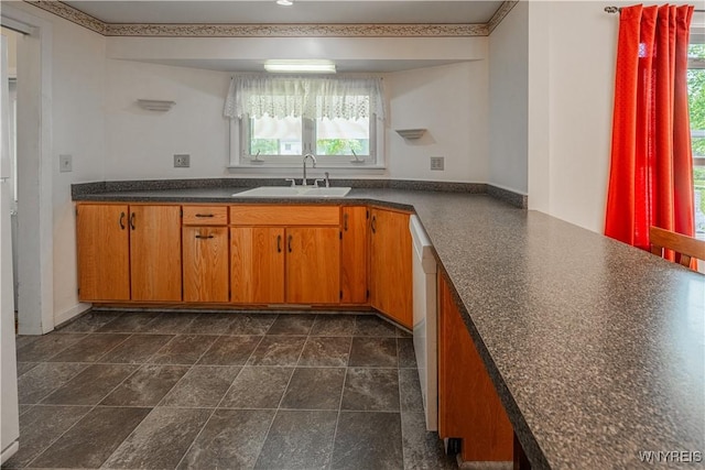 18 Eisenhower Dr, Lockport-City, NY 14094 - kitchen featuring dark countertops, brown cabinetry, and white dishwasher