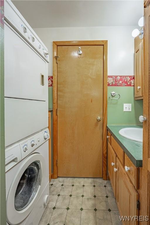 18 Eisenhower Dr, Lockport-City, NY 14094 - washroom with stacked washing machine and dryer and cabinet space