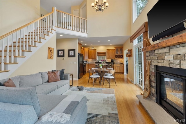 84 Krystyna Ln Unit 6, Cato, NY 13080 - living area with light wood finished floors, a high ceiling, stairway, a fireplace, and a chandelier