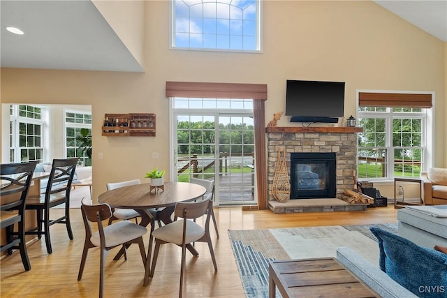 84 Krystyna Ln Unit 6, Cato, NY 13080 - dining room with a stone fireplace, a high ceiling, and light wood-style floors