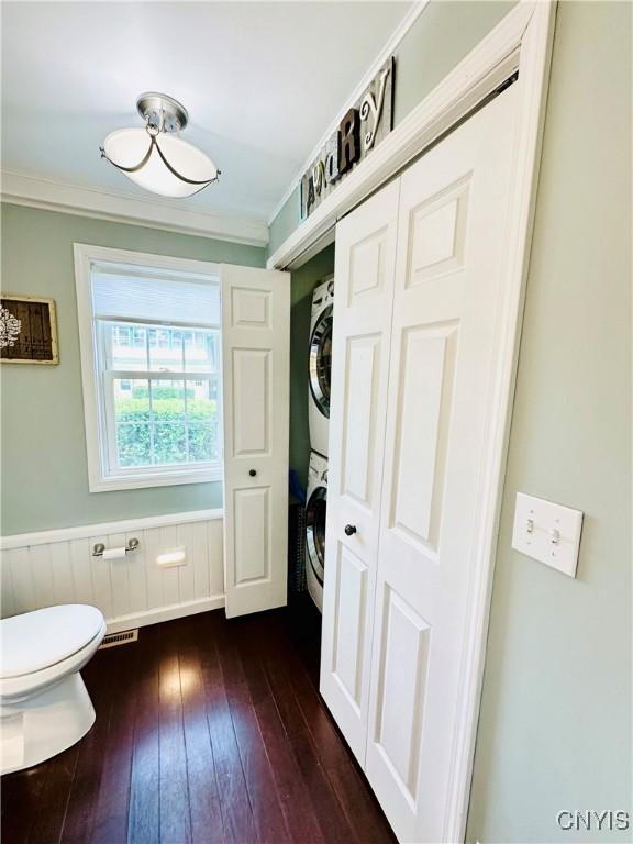 300 Hillsdale Ave, Syracuse, NY 13206 - bathroom with stacked washer / dryer, wood-type flooring, ornamental molding, and a wainscoted wall