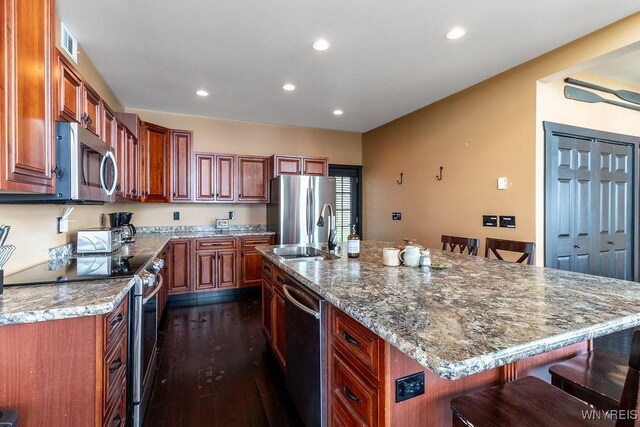 2300 Washington Ave, Wilson, NY 14172 - kitchen with stainless steel appliances, a kitchen bar, dark wood-type flooring, light stone countertops, and recessed lighting