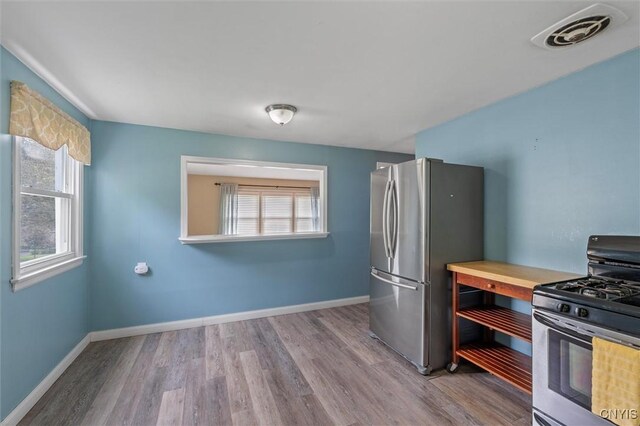130 Hillcrest Rd, Onondaga, NY 13219 - kitchen featuring gas range oven, freestanding refrigerator, and wood finished floors