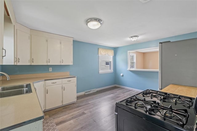 130 Hillcrest Rd, Onondaga, NY 13219 - kitchen with black gas stove, light countertops, light wood-type flooring, and white cabinets