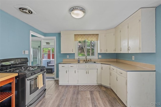 130 Hillcrest Rd, Onondaga, NY 13219 - kitchen featuring gas stove, light countertops, light wood-style floors, and white cabinets