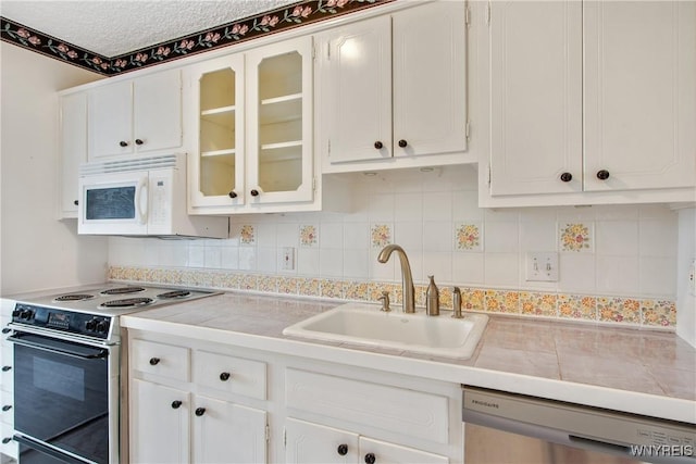 1088 Delaware Ave Unit 3B, Buffalo, NY 14209 - kitchen with white appliances, white cabinetry, light countertops, glass insert cabinets, and decorative backsplash