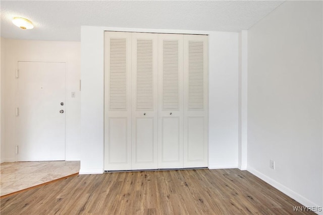 1088 Delaware Ave Unit 3B, Buffalo, NY 14209 - unfurnished bedroom with wood finished floors, a closet, and a textured ceiling