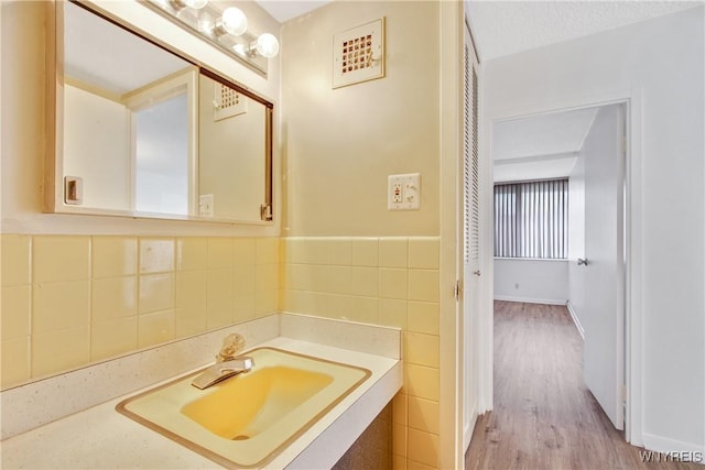 1088 Delaware Ave Unit 3B, Buffalo, NY 14209 - bathroom featuring tile walls, vanity, and wood finished floors