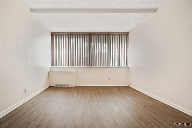 1088 Delaware Ave Unit 3B, Buffalo, NY 14209 - unfurnished room featuring wood finished floors and radiator heating unit
