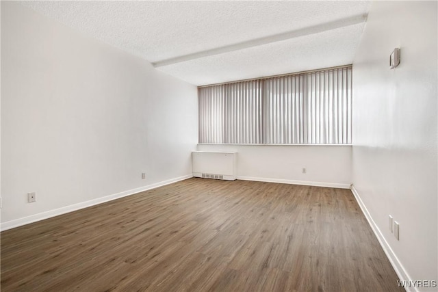 1088 Delaware Ave Unit 3B, Buffalo, NY 14209 - empty room featuring radiator heating unit, wood finished floors, and a textured ceiling