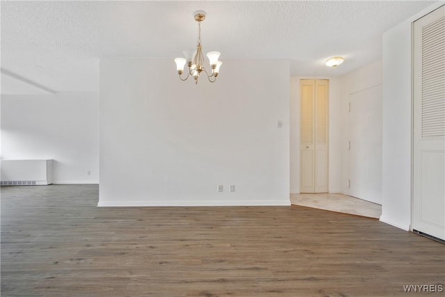 1088 Delaware Ave Unit 3B, Buffalo, NY 14209 - unfurnished dining area with a chandelier, wood finished floors, and a textured ceiling