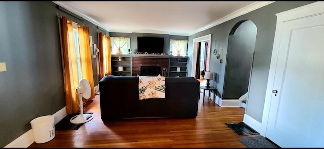 1206 W Water St, Elmira, NY 14905 - living room with a brick fireplace, ornamental molding, wood finished floors, and arched walkways