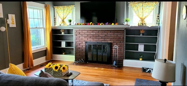 1206 W Water St, Elmira, NY 14905 - living area featuring a brick fireplace and wood finished floors