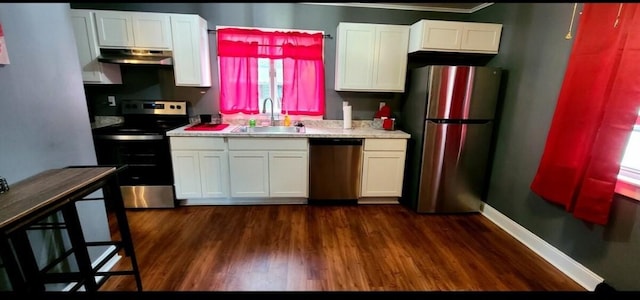 1206 W Water St, Elmira, NY 14905 - kitchen with appliances with stainless steel finishes, white cabinetry, under cabinet range hood, dark wood-type flooring, and crown molding