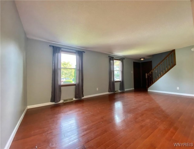790 Mohawk St, Lewiston, NY 14092 - unfurnished living room featuring wood finished floors, stairway, and a textured ceiling
