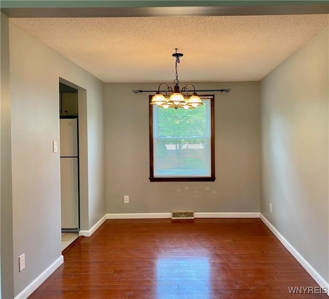 790 Mohawk St, Lewiston, NY 14092 - unfurnished dining area featuring wood finished floors, a chandelier, and a textured ceiling
