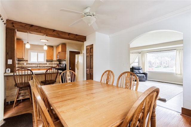 2092 Titus Ave, Irondequoit, NY 14622 - dining area with arched walkways, light wood finished floors, a ceiling fan, and crown molding