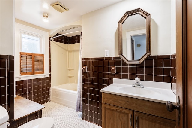 2092 Titus Ave, Irondequoit, NY 14622 - full bathroom with tile walls, vanity, shower / tub combination, a wainscoted wall, and tile patterned floors